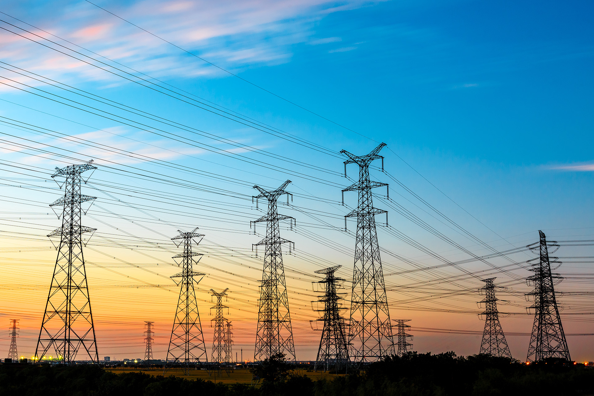 Hochspannungsleitungen und Strommast der Energieübertragung bei Sonnenuntergang