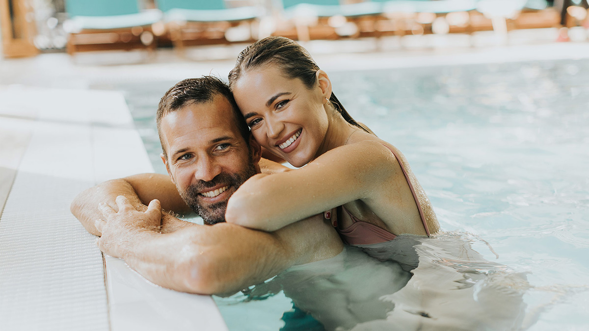 Junges Paar entspannt im Schwimmbecken des Hallenbads
