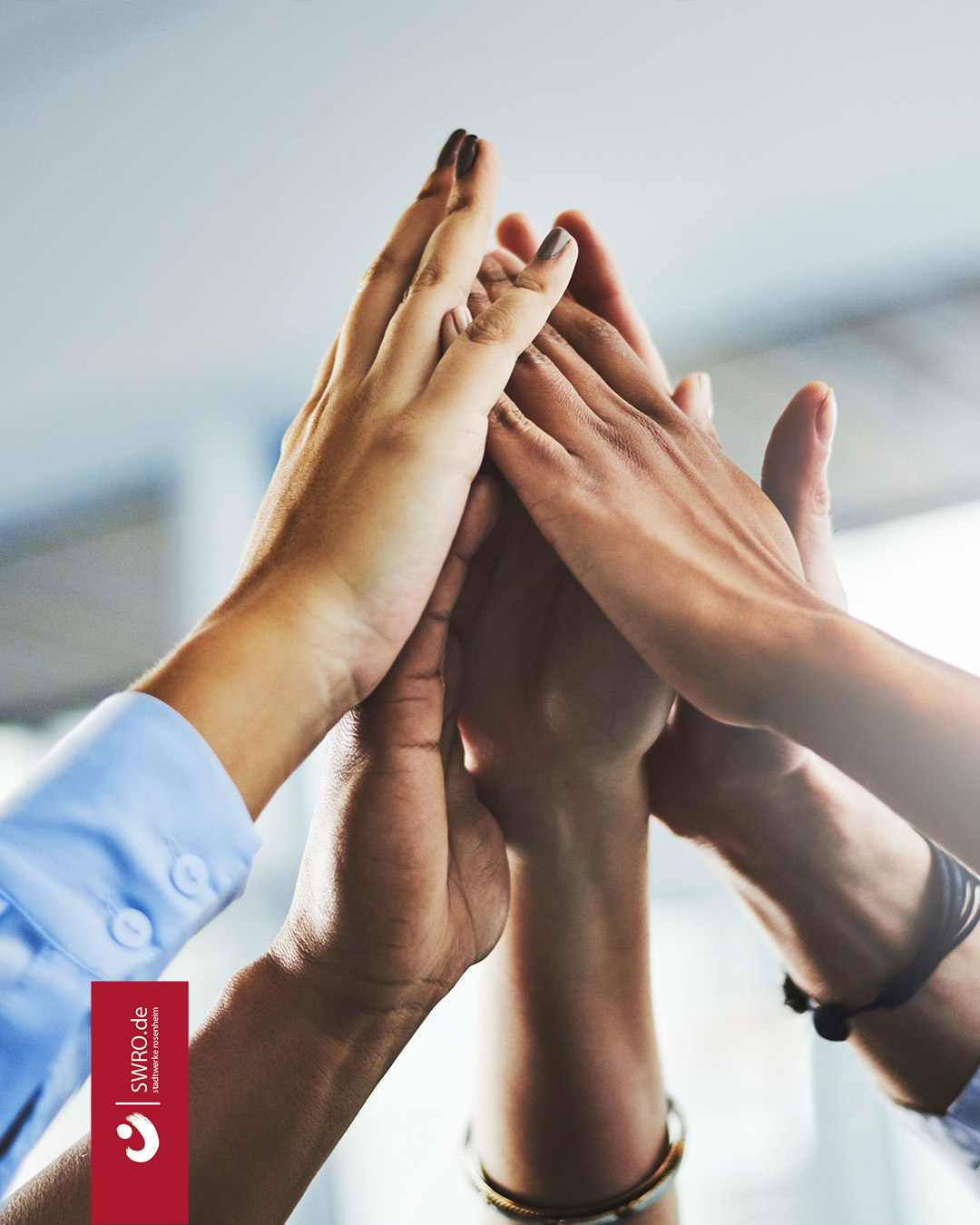 Eine Gruppe Menschen klatscht die Hände zusammen