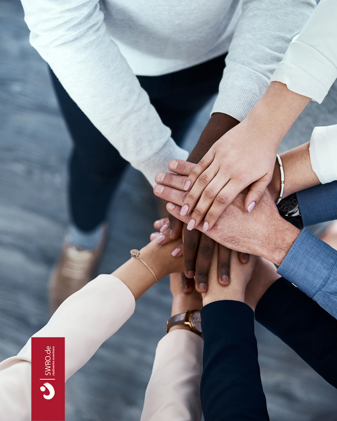Eine Gruppe Menschen legt die Hände übereinander