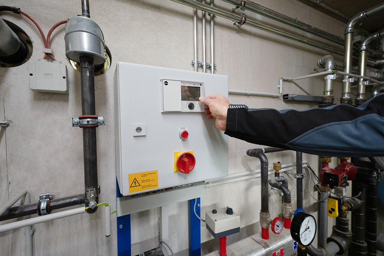 Mitarbeiter stellt Fernwärmeuebergabestation ein