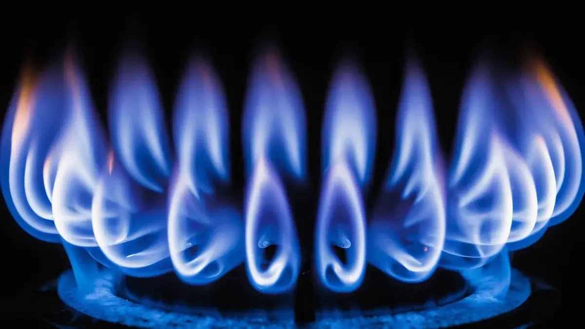 Blaue Erdgasflamme auf einem Gasherd als Symbol für Gaspreise und Energiepreise