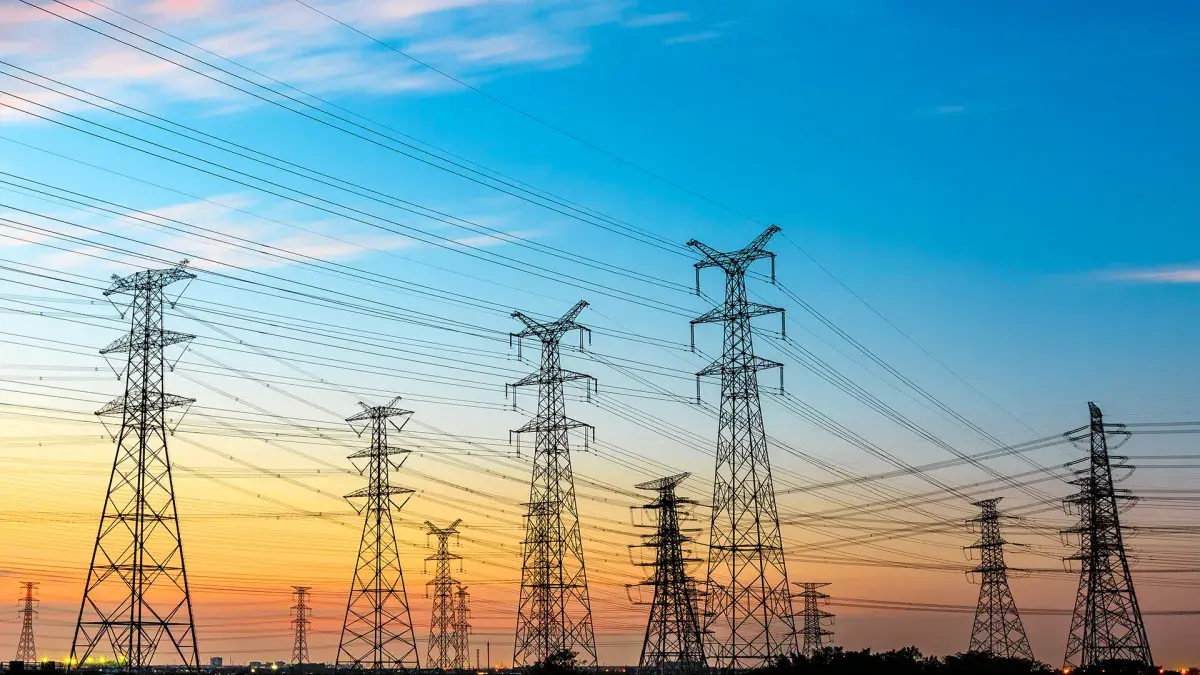 Hochspannungsleitungen und Strommast der Energieübertragung bei Sonnenuntergang