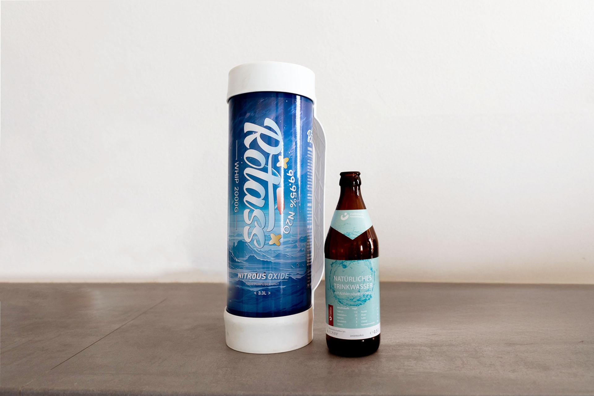 2 Kilo Lachgasflasche neben Wasserflasche