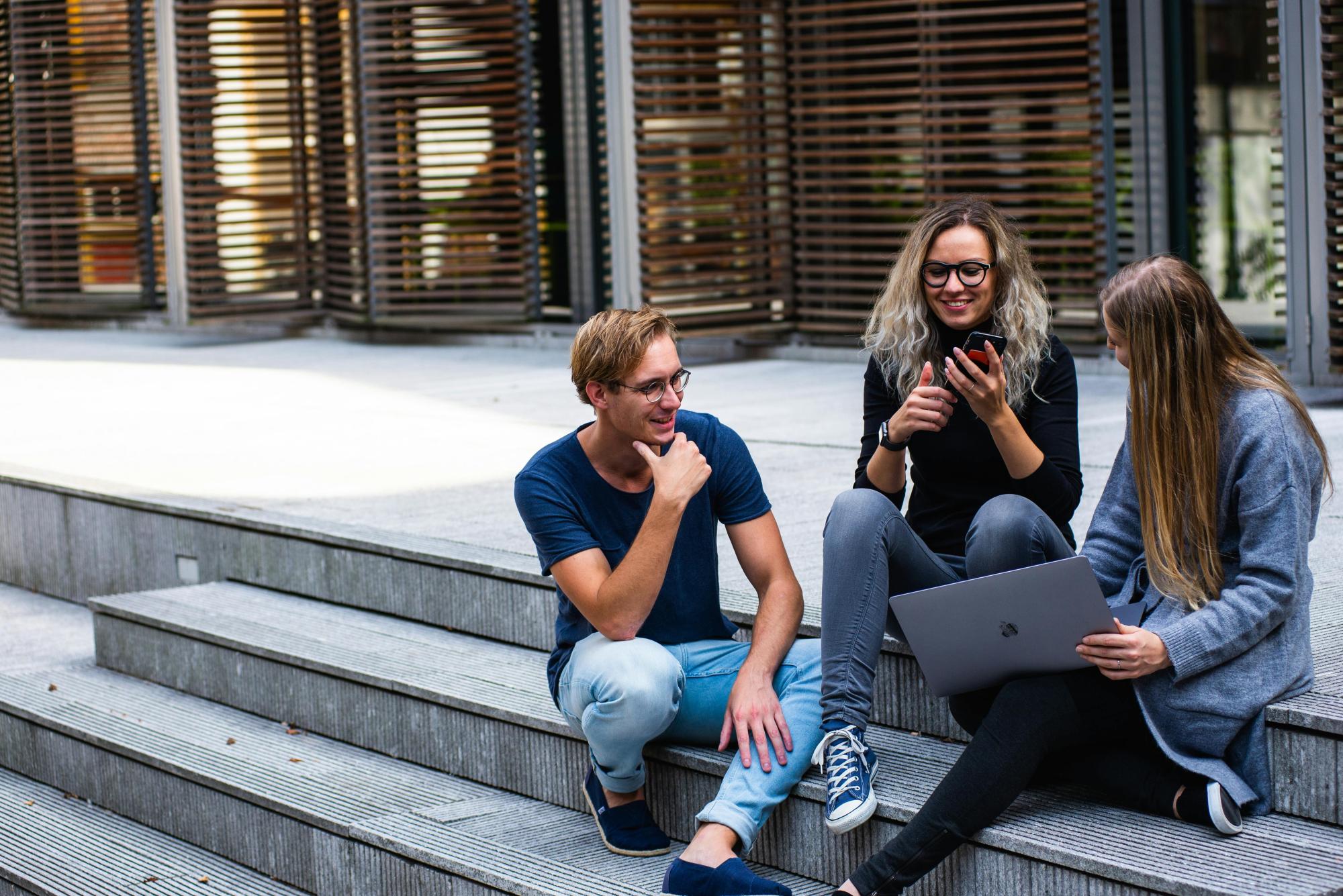 Schüler auf der Treppe sitzend vor der Schule
